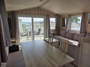 a living room with a table and a couch at 2 bedrooms caravan with a sea view in Poole