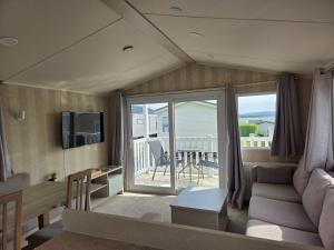 a living room with a couch and a balcony at 2 bedrooms caravan with a sea view in Poole