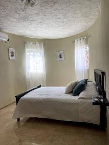 a bedroom with a bed with two pillows on it at Casa Kaibana - 6 Pax, con piscina, cerca del mar in Las Galeras