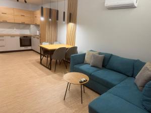a living room with a blue couch and a table at RICH 2 Apartment in Plovdiv