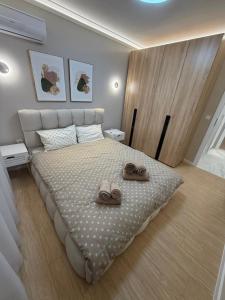 a bedroom with a bed with two pairs of shoes on it at RICH 2 Apartment in Plovdiv