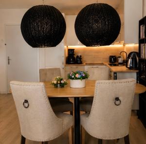 a dining room table with chairs and two pendant lights at PEARL COAST Luxury Rogowo Pool Beach in Rogowo
