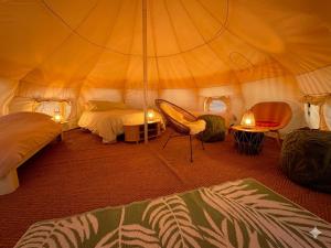 a room with a tent with two beds and a chair at Nest Lodge in Weissbriach