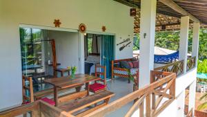 a porch of a house with a table and chairs at Casabela Sargi Serra Grande in Uruçuca