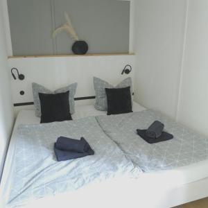 a bed with two hats and pillows on it at Idyllischer Bungalow am Badesee in Reuthen