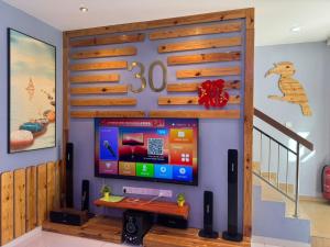 a living room with a flat screen tv on a wall at Pangkor L30 88 Corner villa House in Pangkor