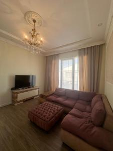 a living room with a large couch and a television at Kobuleti 327 a in Kobuleti