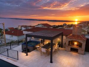 a house with a swimming pool and a fireplace on a balcony at Newly built Villa MarVista with 4 bedrooms,infinity pool & stunning sea and mountain views in Rtina