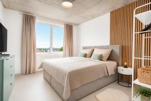 a bedroom with a bed and a large window at Apartmány Gočárova třída in Hradec Králové