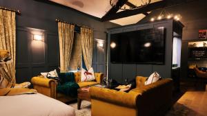 ein Wohnzimmer mit zwei Sofas und einem Fernseher in der Unterkunft Black Rabbit Croston Boutique Hotel & Restaurant in Croston
