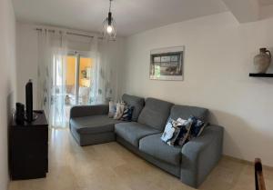 a living room with a couch and a tv at A spacious apartment with an ocean view in Mijas Costa