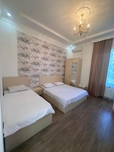 a bedroom with two beds and a chandelier at Kobuleti 327 a in Kobuleti