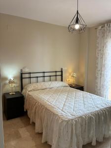 a bedroom with a large bed with a white comforter at A spacious apartment with an ocean view in Mijas Costa +24 photos