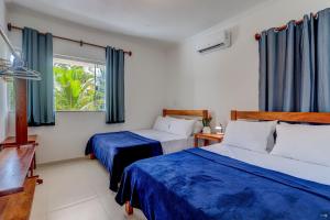 a bedroom with two beds and a window at Casabela Sargi Serra Grande in Uruçuca +56 photos