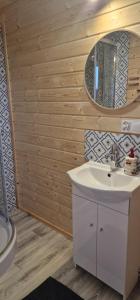 a bathroom with a sink and a mirror at Niezła Szopka domki nad jeziorem in Nowe Guty +41 photos