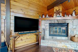 a large flat screen tv in a living room with a fireplace at Mountain View Chalet in West Dover