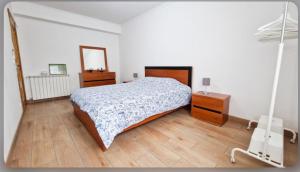 ein Schlafzimmer mit einem Bett, einer Kommode und einem Spiegel in der Unterkunft Cocoon pour 6 personnes in Mirandela