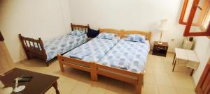 two beds in a small room with a table and a table at Oasis - Oaza in Sutomore
