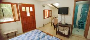 a bedroom with a bed and a television and a desk at Oasis - Oaza in Sutomore