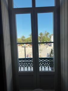 a door with two windows and a view of a park at Casa da Praça- Boutique Rooms in Tavira
