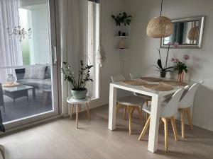 a dining room with a white table and chairs at Lake view Helmi in Jyväskylä