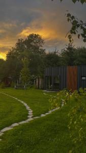 a house with a stone path in the grass at TinyHouses & Garden in Geceľ