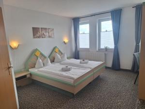 a bedroom with a bed in a room with windows at Hotel am Zellwald in Großschirma