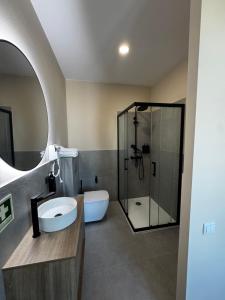 a bathroom with a shower and a sink and a toilet at Casa da Praça- Boutique Rooms in Tavira