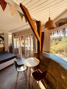 a bedroom with a bed and a table and chairs at Casa Fluila in Praia do Rosa