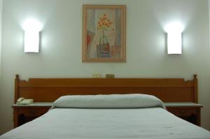 a bedroom with a bed with two lights on the wall at Hotel París in Poio