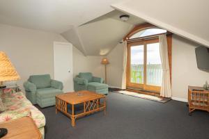 a living room with two chairs and a table at Anchorage Inn & Marina in Ocracoke