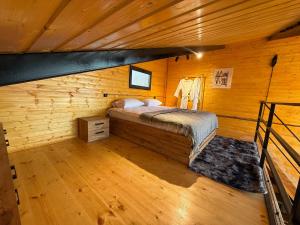 a bedroom with a bed in a wooden cabin at West Coast Cottage Buknari in Buknari