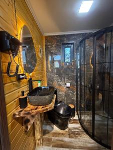 a bathroom with a sink and a glass shower at West Coast Cottage Buknari in Buknari +24 photos