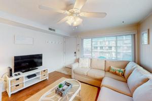 a living room with a couch and a flat screen tv at North Point Condo 301 in Ocean City