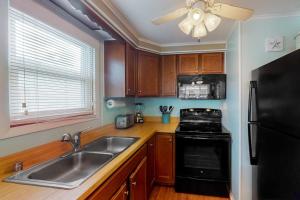 a kitchen with a sink and a black refrigerator at North Point Condo 301 in Ocean City