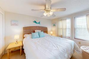 a bedroom with a white bed with a ceiling fan at North Point Condo 301 in Ocean City