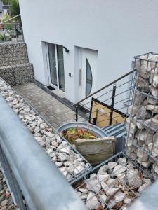 a building with a staircase and some rocks at Helle Wohnung im schönen Allgäu in Kraftisried