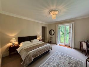 a bedroom with a large bed and a large window at Blackhill Woods Retreat in Abbeyleix