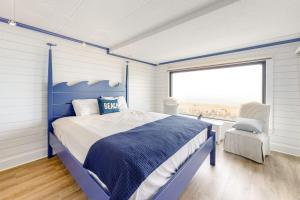 a bedroom with a blue bed and a window at Marigot Beach Condo in Ocean City