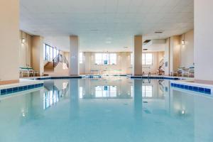 a large swimming pool in a large room with blue tiles at Marigot Beach Condo in Ocean City