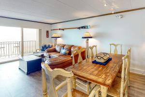 a living room with a wooden table and a couch at Marigot Beach Condo in Ocean City +16 photos