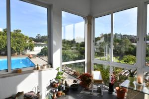 a kitchen with windows and a view of a swimming pool at Casa do Sol Wellness Villa in Óbidos