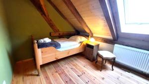 a bedroom with a bed and a chair in a attic at Ferienwohnung Blauregen - NEU ab März 2026 in Hohnstein