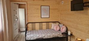 a bedroom with a bed with pillows and a television at Niezła Szopka domki nad jeziorem in Nowe Guty