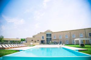 een zwembad voor een gebouw met stoelen bij Amérian Villa Maria Park Hotel in Villa María