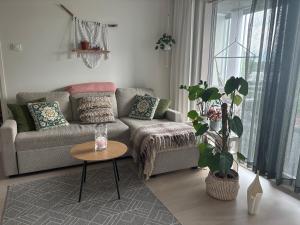 a living room with a couch and a table at Lake view Helmi in Jyväskylä