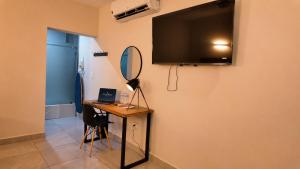 a room with a desk and a television on a wall at Hotel Maioris Kumate Culiacán in Culiacán