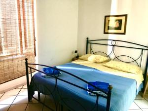 a bedroom with a bed with blue sheets and a window at Casa Lorenzo in Stromboli
