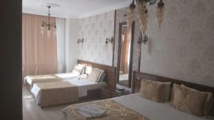 a bedroom with two beds and a large mirror at Şirince otel in Amasya