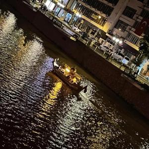 a boat traveling down a river at night at Şirince otel in Amasya +2 photos